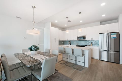 Modern kitchen w/ island seating flowing seamlessly into the dining space.