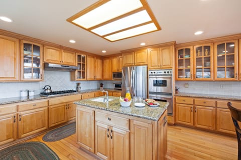 Kitchen features an island and stainless steel appliances.