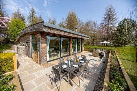 Exterior of Percy lodge with private patio dining area at Brompton Lakes, near Richmond Yorkshire.