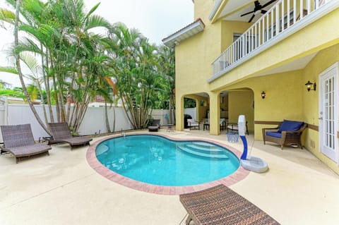 A tropical private pool area surrounded by lush palms, loungers for soaking up the sun, and covered patio seating—your own secluded outdoor escape.