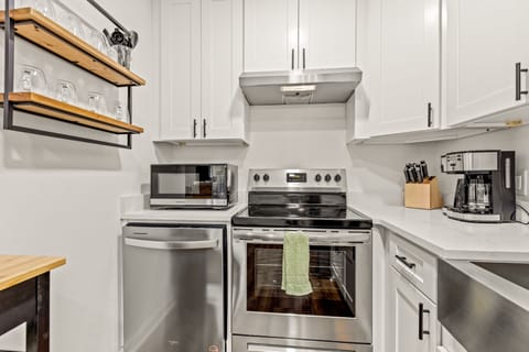 Fully stocked kitchen with stainless steel appliances, a farmhouse sink