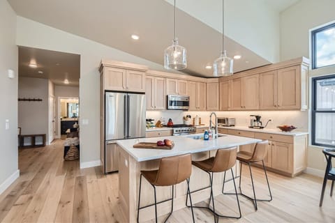 Prepare a gourmet meal in this chef-inspired kitchen featuring sleek quartz countertops and a spacious island with seating for three. High-end Viking appliances, under-cabinet lighting, and warm wood-toned cabinetry