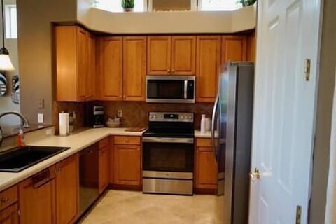 Kitchen with large sink, full stove/oven and microwave and fridge.