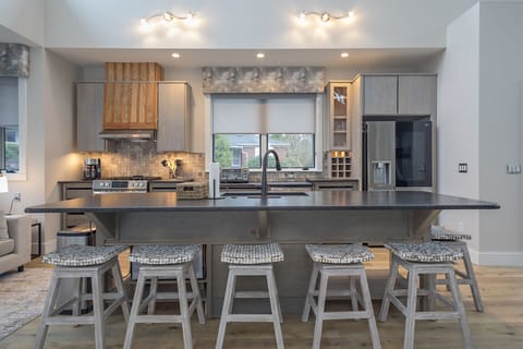 Well-equipped kitchen with island seating for 6, modern appliances, and drip-style coffee maker
