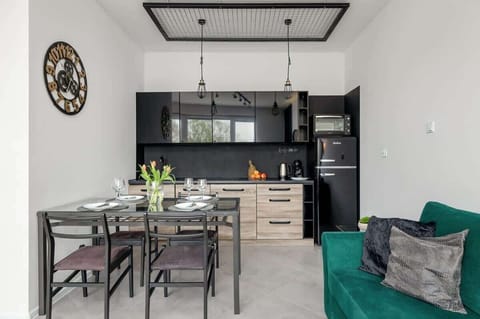 A functional kitchenette with wooden cabinets, black countertops, and all the essentials for cooking.
