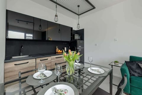 A well-equipped kitchenette with a dining area and contemporary lighting, perfect for everyday use.