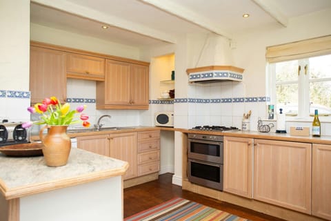 Kitchen with oven and hob, cooker hood, sink, microwave, window