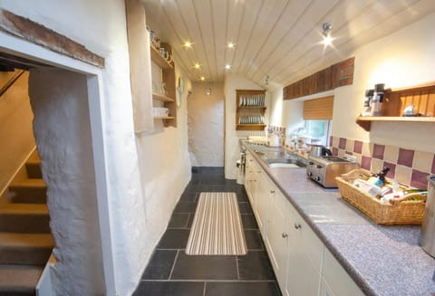 Tal y Gaer Cottage kichen with tiled floor and runner. White base cottage