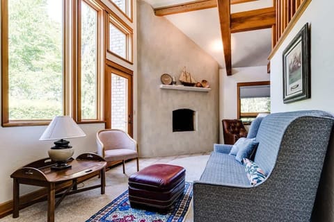 Bright living room with vaulted ceilings, wood beams, and a cozy fireplace. A welcoming space to unwind after Ducks game day at Autzen Stadium or while exploring Eugene’s Coburg Road dining and shopping district.