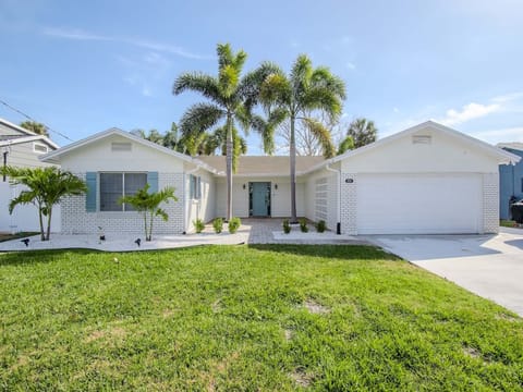 Florida coastal home with palm trees and blue door & shutters

