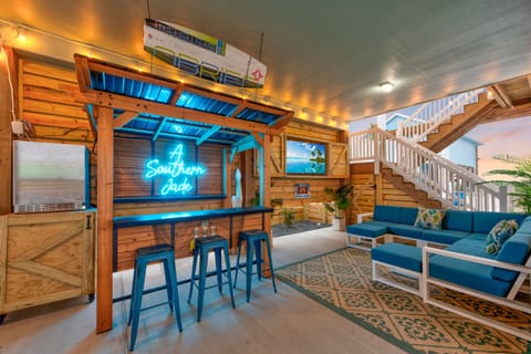 Relax in your stylish Southern-themed lounge, complete with a glowing neon bar, cozy seating, and tropical accents that create the perfect atmosphere for unwinding.