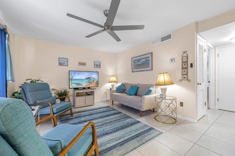Cozy living room with blue accents and a ceiling fan for comfort