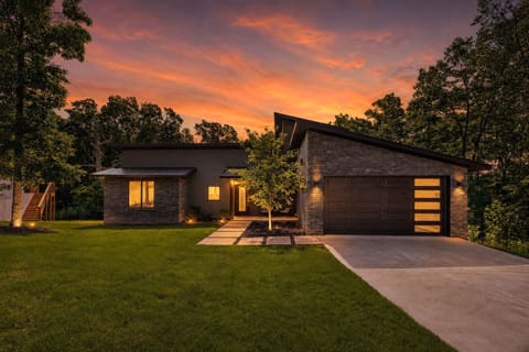 Rocky Ridge Chalet glowing at golden hour — your modern Ozarks escape in Bella Vista.
