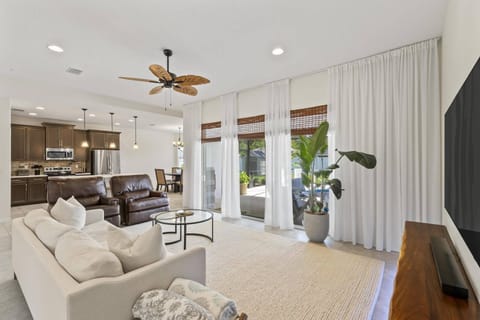Relax in this beautifully decorated open-concept living, dining, and kitchen space, overlooking the patio and pool for a cozy, stylish retreat.