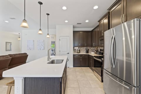 Full-size kitchen with a stove, oven, dishwasher, island, refrigerator, and all the essentials for your convenience.