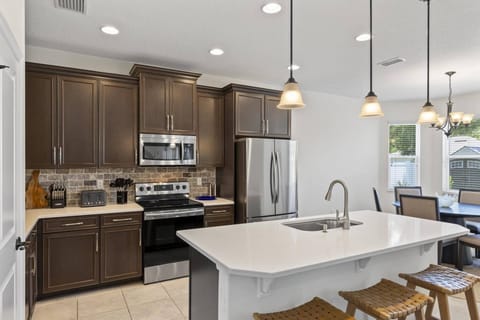 A spacious, fully-equipped kitchen with island and counter seating, perfect for preparing meals and enjoying casual bites in a stylish inviting space.