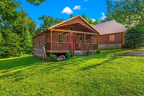 A classic log cabin exterior surrounded by lush green lawn welcomes you home from the moment you arrive.