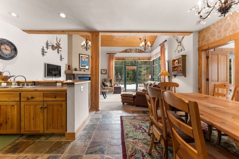 Gather around your spacious dining table while enjoying the open-concept kitchen and cozy living room with natural light streaming through patio doors.