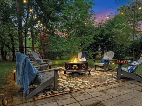 Gather at the firepit as the string lights flick on — marshmallows toasting, the whole group pulled into one circle. After a day at Oaklawn, this is where the night lands.