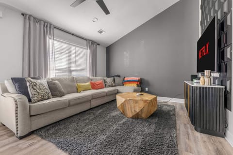 The striking dark grey accent wall and vaulted ceiling create a sophisticated backdrop for your morning coffee or late-night movie marathon. We’ve added pops of yellow and orange pillows to keep the mood bright, even on rainy Georgia days.