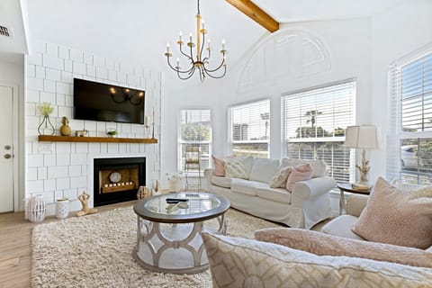 Exquisite and comfortable living room with elegant decor, a smart TV, and a decorative fireplace.