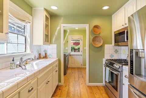 Cottage kitchen includes modern stainless steel appliances