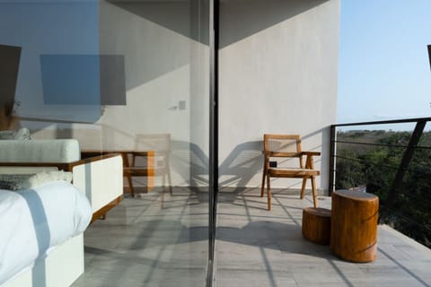 Balcony with wood seating and treetop views.