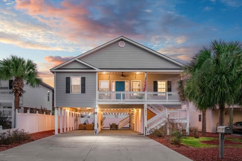 Coastal charm meets modern comfort — the exterior glows at dusk as a welcoming start to your stay.