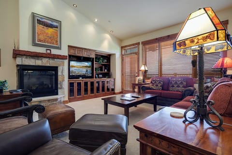 Sink into plush leather seating by your crackling fireplace, where warm wood tones and elegant furnishings create the perfect retreat for cozy evenings.