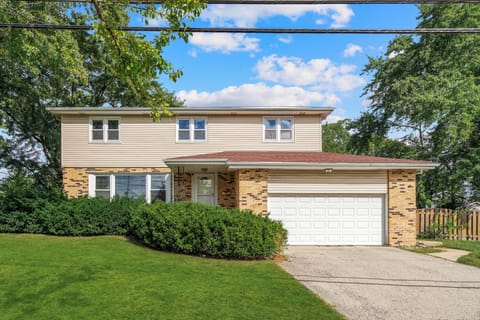 Classic brick exterior with two-car garage and manicured lawn.