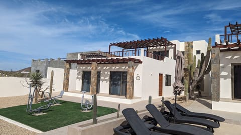 Casa Arena exterior with front porch, and fitness equipment on turf area.