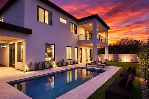 Private outdoor space with heated pool, sun loungers, outdoor dining, built-in BBQ grill, and gorgeous mountain views.