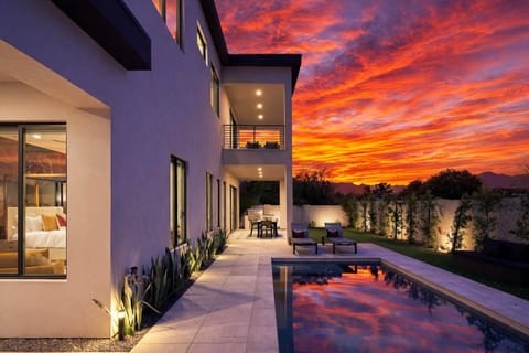 Private outdoor space with heated pool, sun loungers, outdoor dining, built-in BBQ grill, and gorgeous mountain views.