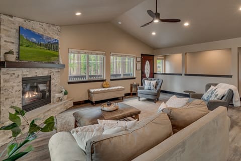 - Fireplace living room with rustic stone surround décor  
- Spacious seating area with mountain charm and natural light  
- Perfect cabin lounge for cozy evenings and family fun
