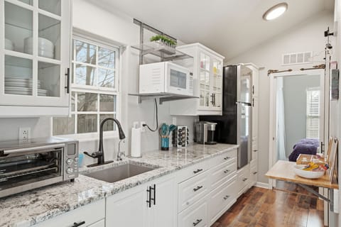 Bright kitchen space stocked with cookware, dinnerware, and essentials for home cooked meals.