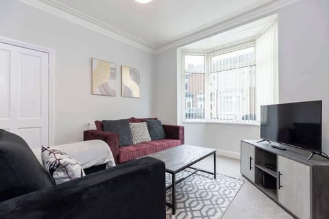 Settle into the spacious lounge with a plush sofa and armchair, ideal for relaxing and binge-watching on the large internet-based TV