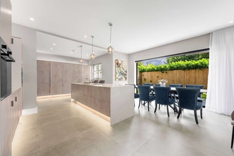 Gather your group around the dining table with the kitchen right behind you and greenery just beyond the glass