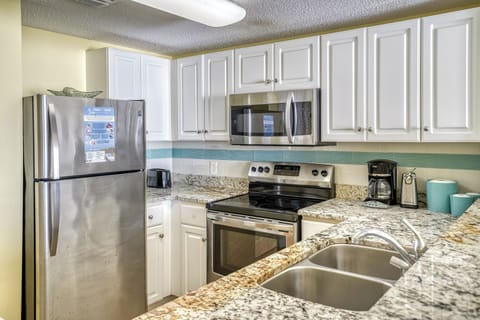 Fully stocked kitchen with stainless steel appliances.