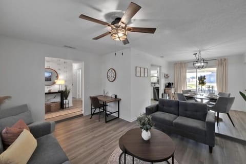 Spacious open living area with modern decor, desk workspace, and natural light.
