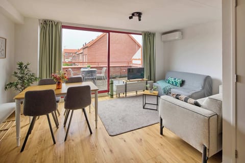 Bright and open living area with a cozy lounge corner and balcony access.