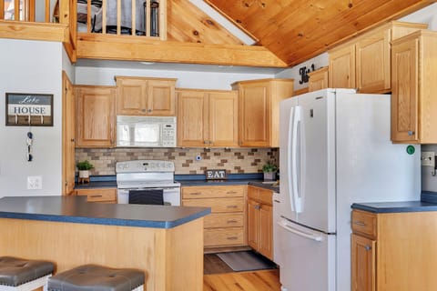 The kitchen is fully stocked with cooking supplies; opens to the living room