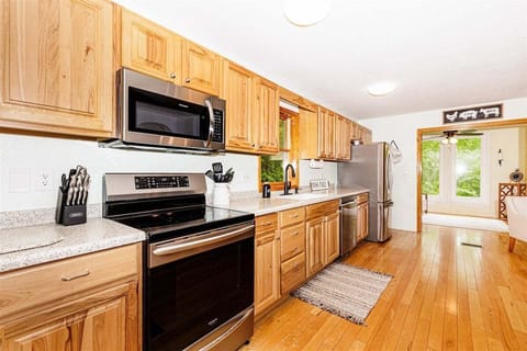 Modern farmhouse kitchen with stainless steel appliances and wood cabinets, perfect for families visiting Bryson City.