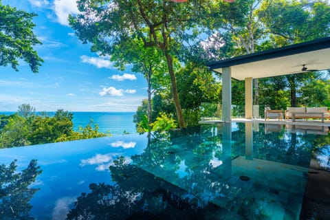 Infinity pool overlooking the Pacific Ocean, surrounded by tropical forest.