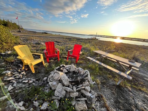 Find your peace on this waterfront seating area, where the combination of bright Adirondack chairs and the serene water vista creates an idyllic setting for relaxation.