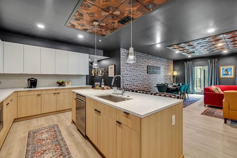 The fully equipped modern kitchen features culinary essentials, stainless steel appliances, and island bar seating.