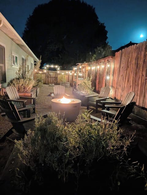 Side yard with propane fire plt, Adirondack chairs and cornhole 