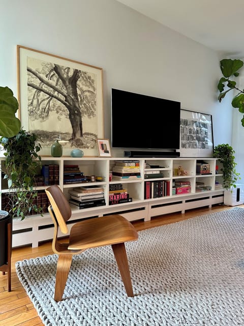 Living room with local art, design books, cozy blankets, smart TV, and Sonos.