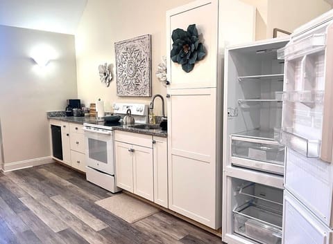 Kitchen with full size fridge, mini-fridge, oven,  four-burner range.