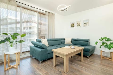 A bright living room with large windows, white walls, and decorative potted plants creates a welcoming and relaxing space for rest.