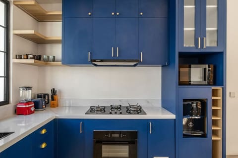 Spacious dining and kitchen area with a pop of blue and ample natural light.